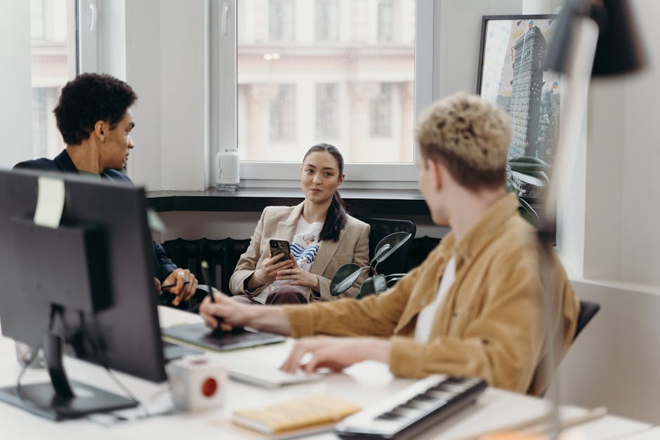 A diverse group of colleagues engaged in a team meeting in a modern office environment.