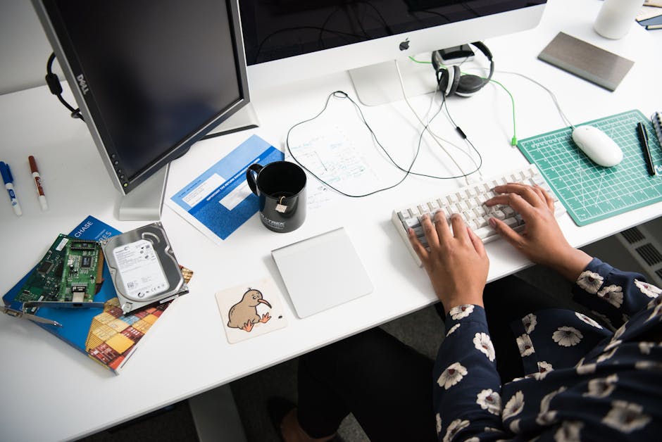 Overhead view of a person typing at a desk in a modern office environment.